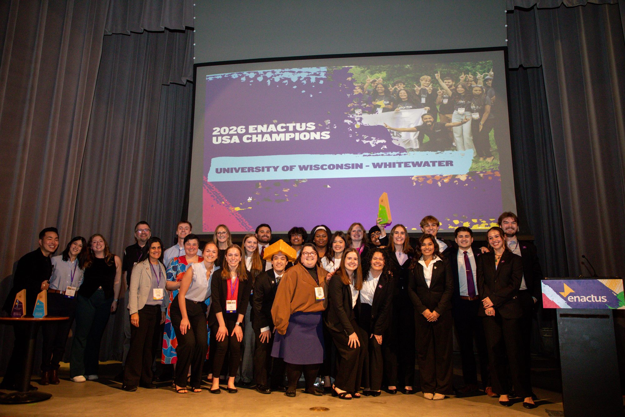 The 2026 team on stage in Denver under the 2026 Enactus USA Champions slide